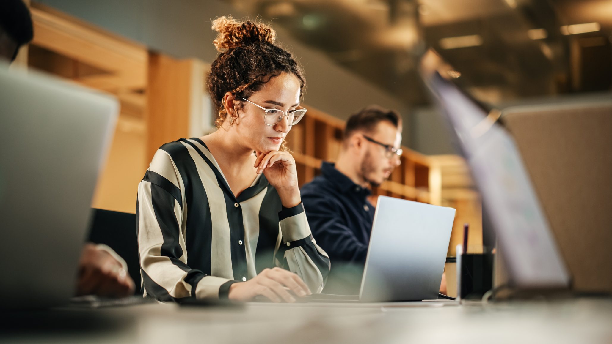 Professionals working at laptops in a shared workspace